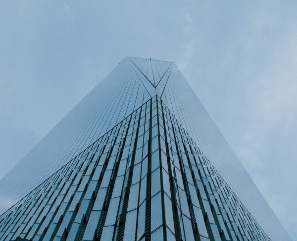 A low angle shot of a tall skyscraper business building in NYC with beautiful clear sky