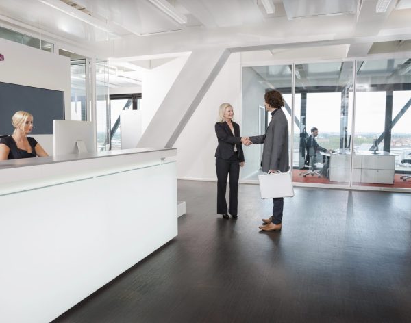 Woman shaking hands with visitor at reception