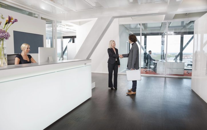 Woman shaking hands with visitor at reception