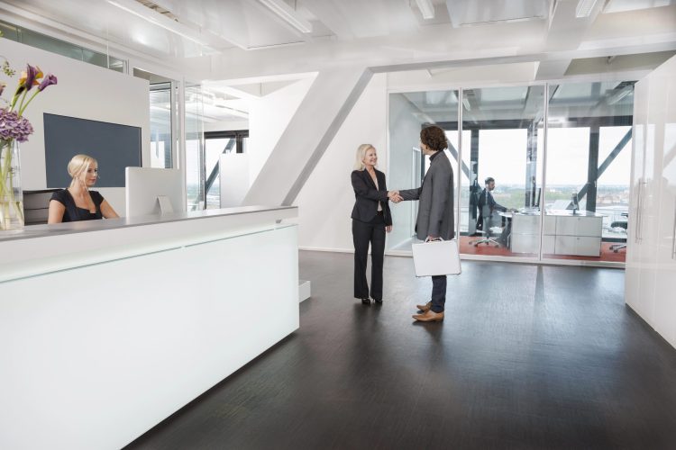 Woman shaking hands with visitor at reception
