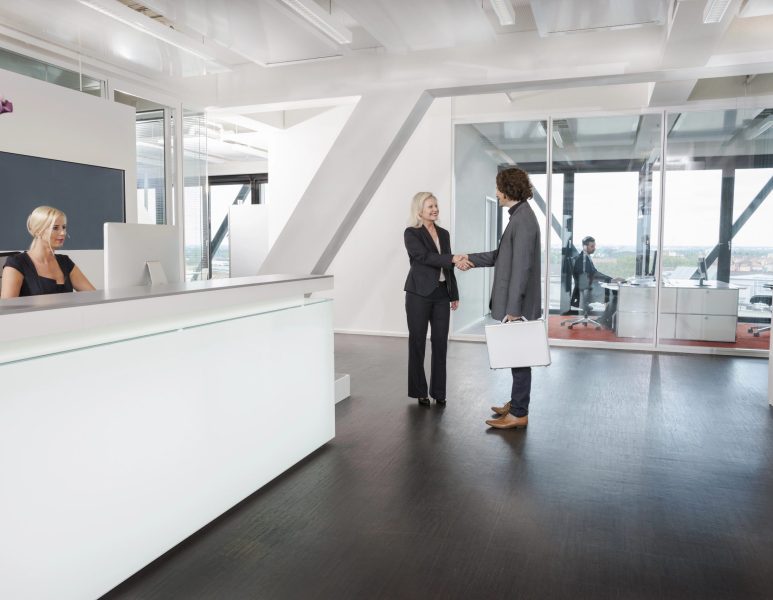 Woman shaking hands with visitor at reception