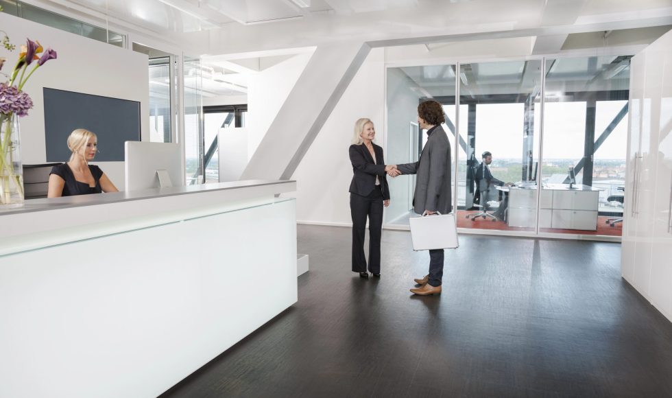 Woman shaking hands with visitor at reception