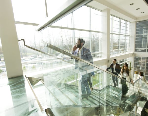 Young business people climb the stairs in the office building
