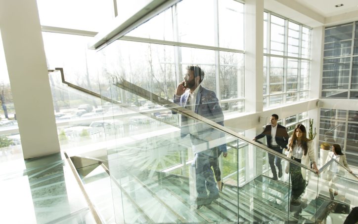 Young business people climb the stairs in the office building