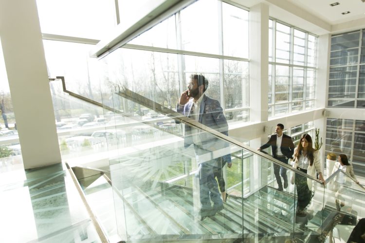 Young business people climb the stairs in the office building