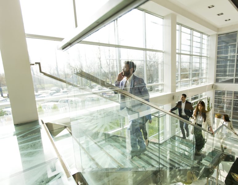 Young business people climb the stairs in the office building