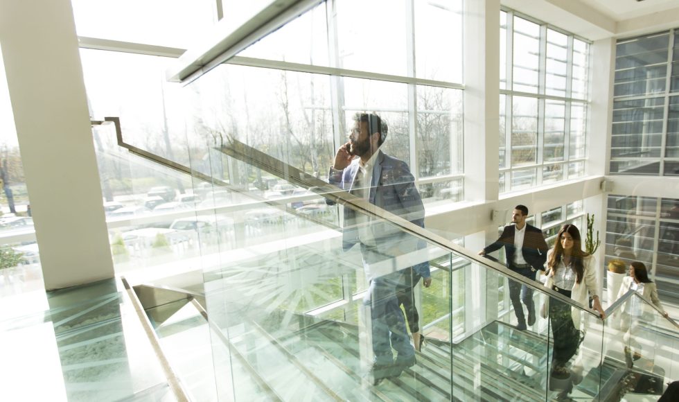 Young business people climb the stairs in the office building